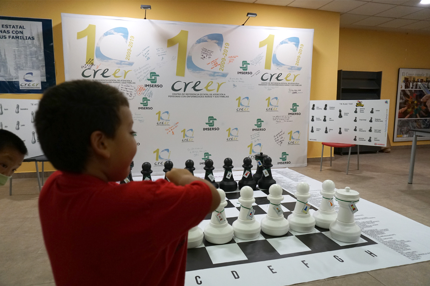 Niño jugando con el ajedrez gigante en el centro CREER de Burgos